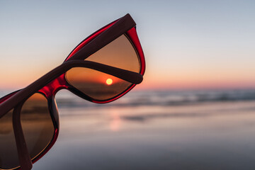 Close-up of red sunglasses on the beach
