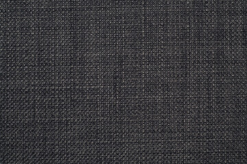 The background is a rough, dense linen fabric with a distinct braid weaving in black and gray...