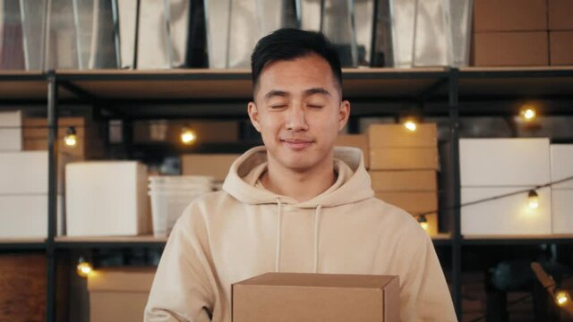 Delivery asian man holding cardboard boxes during pandemic quarantine home isolation. Fast and free supermarket Delivery. Online shopping and Express e-commerce.