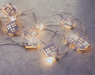 Fototapeta na wymiar luminous garland with paper houses. New year and Christmas background in light tones.