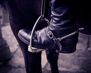 Detalle de bota de montar a caballo con espuela sobre estribo