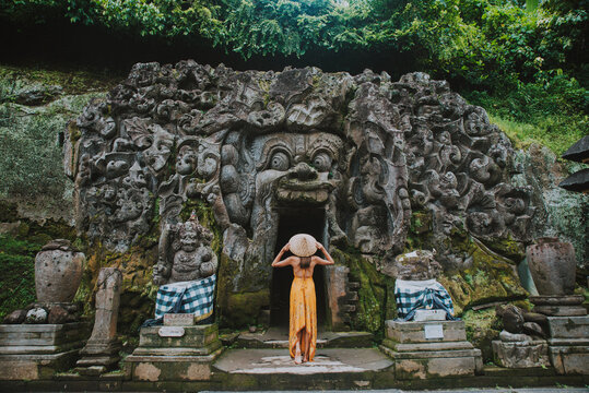 Beautiful girl visiting the goa gajah temple in ubud , Bali