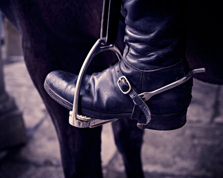 Detalle de bota de montar a caballo con espuela sobre estribo