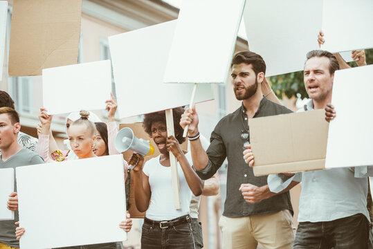 Public demonstration on the street against social problems and human rights. Group of multiethnic people making public protest