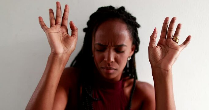 Faithful black woman praying raising arms in the air. African mixed race famel in prayer