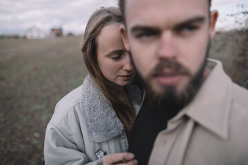 a couple in love walks in an open soybean field in the evening in cloudy weather