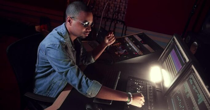 Producer mixing music on sound mixer control panel in studio