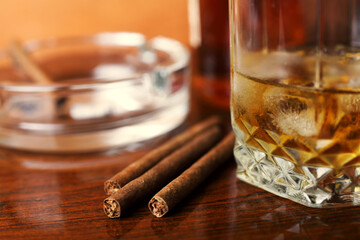 Whiskey with ice cigars on the table close-up, small depth of field, place for your text.