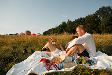 young happy couple on a picnic in the field