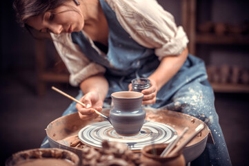 Stylish pottery molding a vase of clay on a potter's wheel. Handmade.