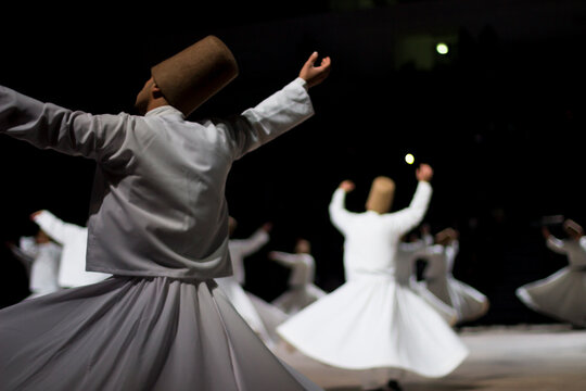 Dervishes perform on the stage for Mevlana