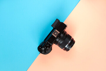 Flat lay of camera on blue and pink background