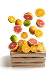 Wooden box of assorted oranges and tangerines flying, isolated from the white background