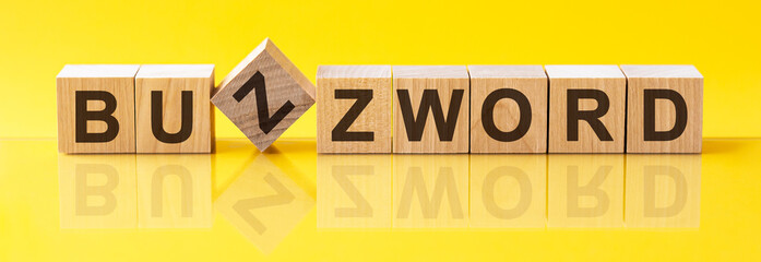 BUZZWORD word is made of wooden building blocks lying on the yellow table