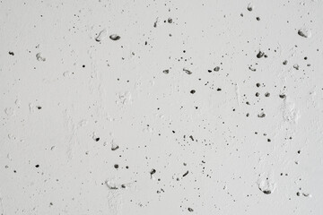 Textured concrete wall painted with white paint.