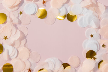 white pink and gold paper confetti with stars on a pastel pink background