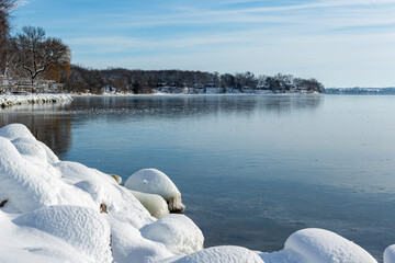 snowy rocks andfrozen lake in winter