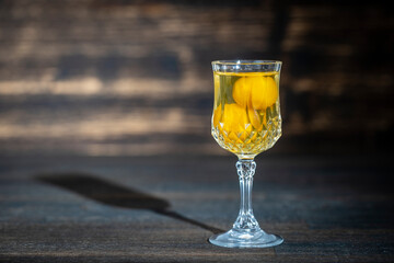 Homemade tincture of yellow cherry plum wine crystal glass on wooden background, Ukraine, close up