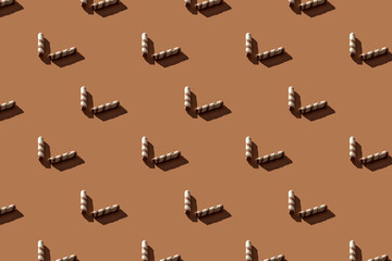 Broken wafer rolls seamless pattern with hard shadows on a brown background. Minimal sweet food concept