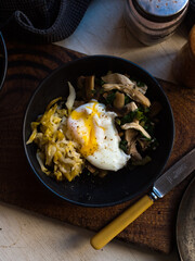 Poached egg and fermented vegetables in black bowl