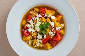Colorful summer salad with tomato, peach and feta cheese , close up