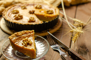 Fresh Homemade Pumpkin Pie on rustic wooden background made for Thanksgiving or halloween.