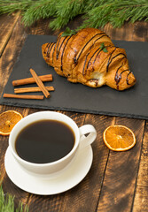 Christmas coffee and croissant with christmas tree on wooden background