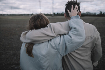 a couple in love walks in an open soybean field in the evening in cloudy weather