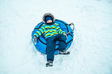 little kid in snow tube. winter time