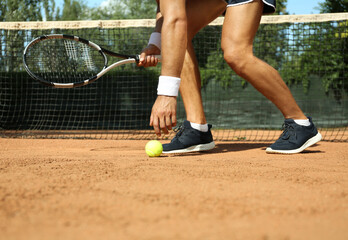 Fototapeta na wymiar Sportsman playing tennis at court on sunny day, closeup