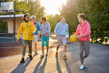 friendly group of caucasian teenagers boys ready to play basketball, athletic young guys full of energy and strength. people, youth, young generation concept