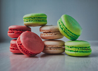 Colored tasty macaroons on wooden grey background