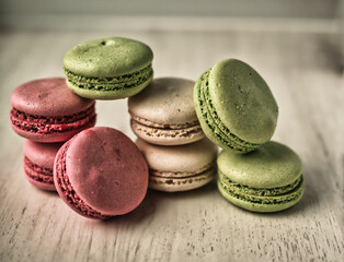 Colored tasty macaroons on wooden grey background