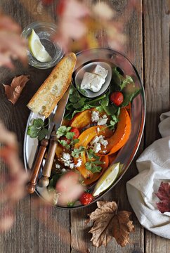 Oven baked pumpkin with feta cheese and spinach. Overhead view