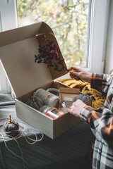 Work-life balance, cosy at home, relaxing indoors concept. Winter fall cozy mood concept. Still life details with Scented Aromatherapy Candle, cacao and cup and knitted sweater