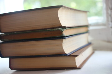 Stack of old hardcover books on a wooden surface. Knowledge education concept