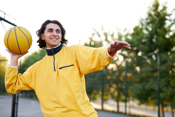 Fototapeta premium athletic young boy in casual wear keen on basketball, enjoy playing outdoors, sport concept