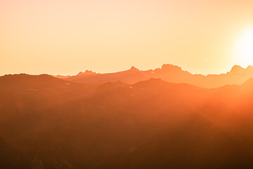 Fototapeta na wymiar Beautiful Mountain And Sunset at swiss Alps. Dark Silhouette of Mountains on Yellow Sunrise Background