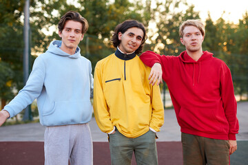 portrait of young stylish teenagers outdoors, caucasian boys in colouful fashionable casual hoodies...