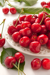 Fresh red cherry in a plate on the white background