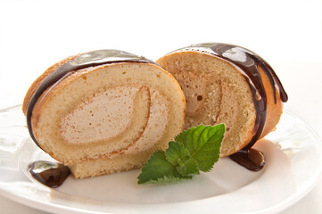 Chocolate swiss roll cake with mint on the white background