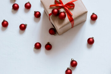 holiday box with red ribbon on white background with christmas balls, merry christmas