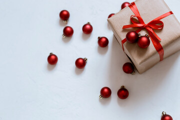 holiday box with red ribbon on white background with christmas balls, merry christmas