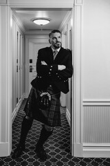handsome mature courageous stylish man (gay) scotsman in kilt in fancy hotel room. Style, fashion, lifestyle, culture, travel, ethnic concept. - obrazy, fototapety, plakaty