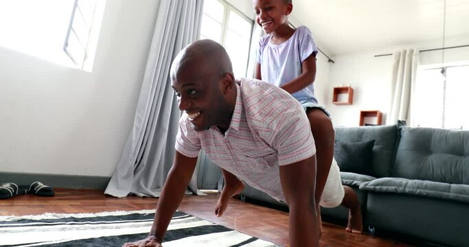 Funny father and child bonding together doing push-ups at home
