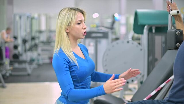 gym trainer controls his client's technique, camera moves