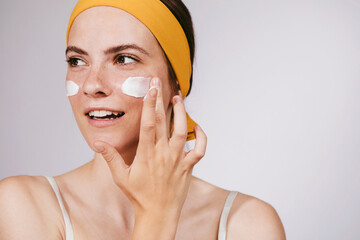 Young Woman Putting Face Cream
