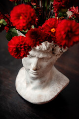 Male bust with red flowers in a head