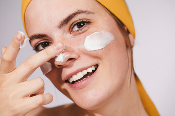 Young Woman Putting Face Cream