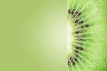 The texture of the cut kiwi on a green background with copies of space.
